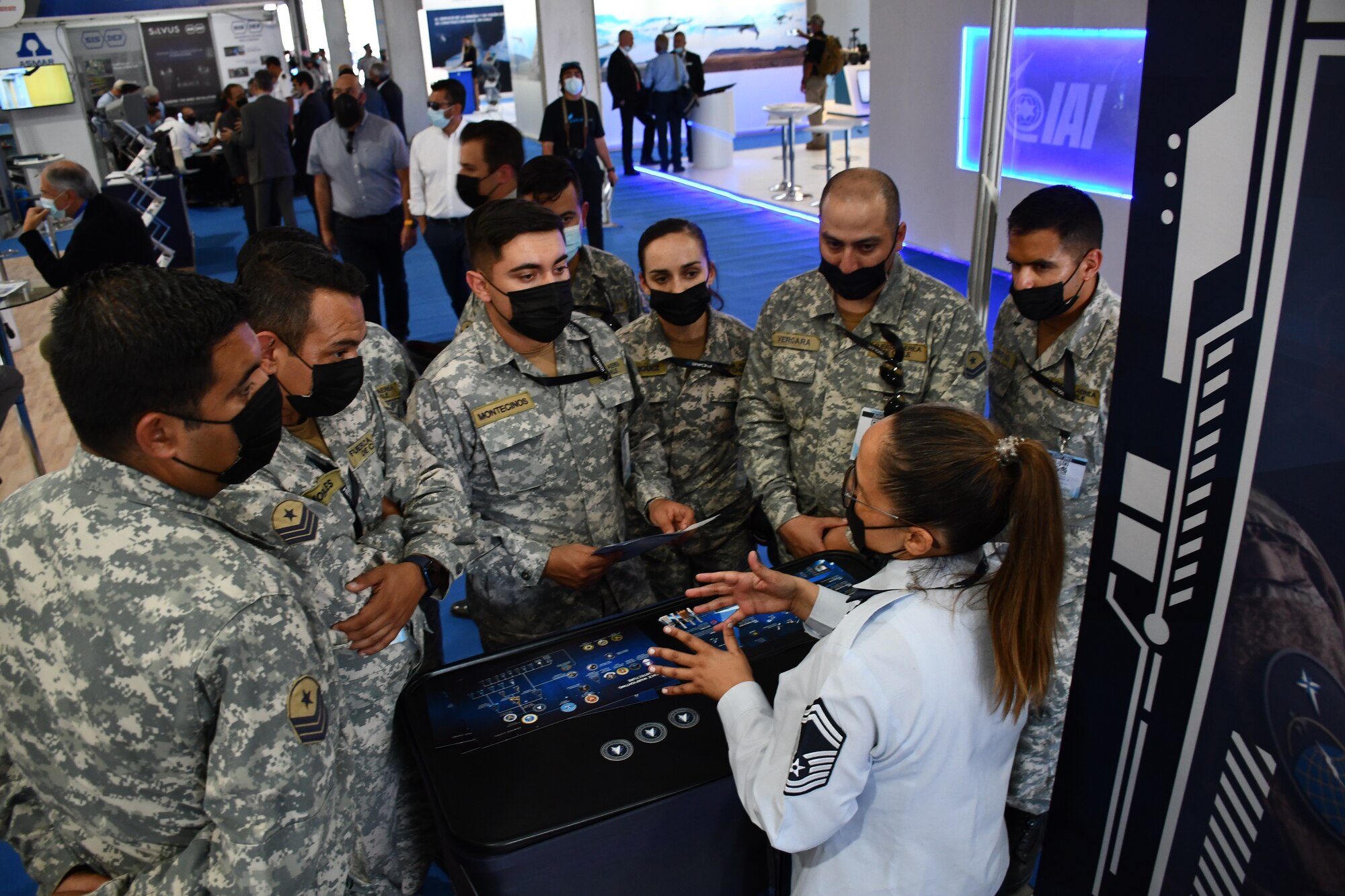 Senior Master Sgt. Julia Valenzuela, 11th Space Warning Squadron, discusses the U.S. Space Force mission with members of the Chilean Air Force on April 5, 2022. U.S. Space Force Guardians hosted a U.S. Space information booth at the FIDAE (Feria International del Aire y del Espacio) Air Show, in which they met with industry partners, distinguished visitors and dignitaries from around the world during the weeklong event. (U.S. Space Force photo by 1st Lt. Rachel Brinegar)