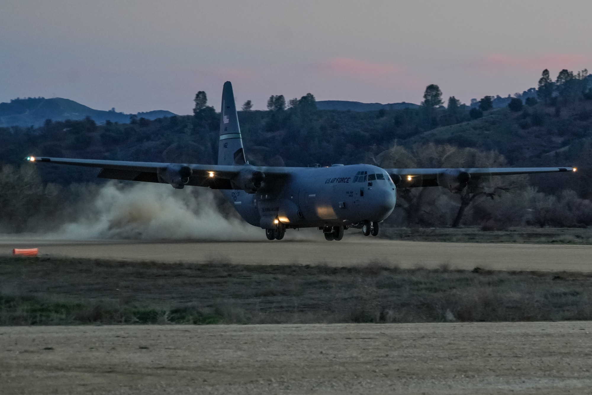 U.S. Air Force personnel assigned to the 621st Contingency Response Wing (621 CRW) load equipment into the back of a C-130J aircraft assigned to the 115th Airlift Squadron on an improvised dirt runway at Fort Hunter Liggett, California, February 8, 2022. Utilizing the C-130J and other Department of Defense aircraft, the 146th Contingency Response Flight and the 621 CRW partnered to accomplish skill-enhancing training and provide airlift support to the 621 CRW's evaluated exercise. (U.S. Air National Guard photo by Staff Sgt. Michelle Ulber)