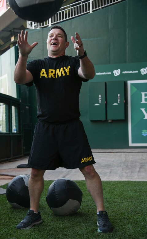 A soldier participates in a medicine ball exercise during a high intensity interval training workout at Nationals Park in Washington, D.C., April 14, 2022.