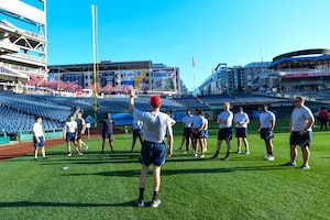 An Airman leads a group of service members from the National Capital Region during high-intensity interval training, known as the Base HIIT Workout, at Nationals Park, Washington D.C., April 14, 2022.