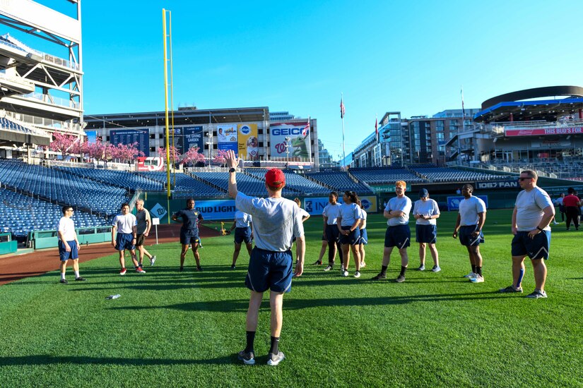 An Airman leads a group of service members from the National Capital Region during high-intensity interval training, known as the Base HIIT Workout, at Nationals Park, Washington D.C., April 14, 2022.