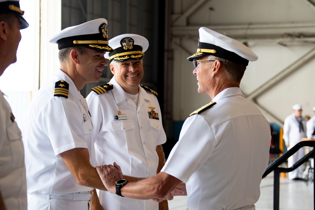 U.S. Navy Rear Adm. Scott Jones, right, commander, Naval Air Forces Reserve, greets Cmdr. Heath Leggett, left, on-coming commanding officer, Fleet Logistics Support Squadron 51, during the VR-51 Change of Command Ceremony, Marine Corps Air Station Kaneohe Bay, Marine Corps Base Hawaii, April, 8, 2022. Cmdr. Joshua Lostetter relinquished command to Leggett. (U.S. Marine Corps photo by Cpl. Samantha Sanchez)