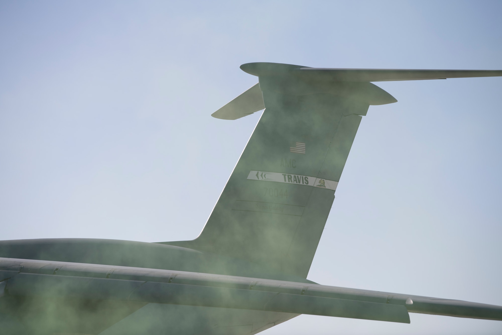 Green smoke from an ignited smoke grenade obscures the view of a C-17 Globemaster III at the Alpena Combat Readiness Training Center, Alpena, Michigan, April 12, 2022.