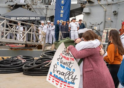 A Sailor assigned to the Arleigh Burke-class guided-missile destroyer USS Mitscher (DDG 57), embraces his wife after the ship's return to homeport, Naval Station Norfolk, April 16.