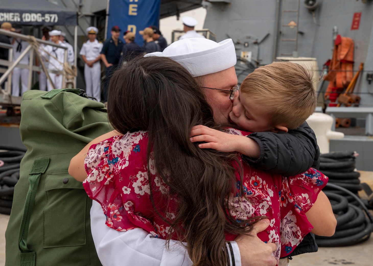 A Sailor assigned to the Arleigh Burke-class guided-missile destroyer USS Mitscher (DDG 57), embraces his family after the ship's return to homeport, Naval Station Norfolk, April 16.