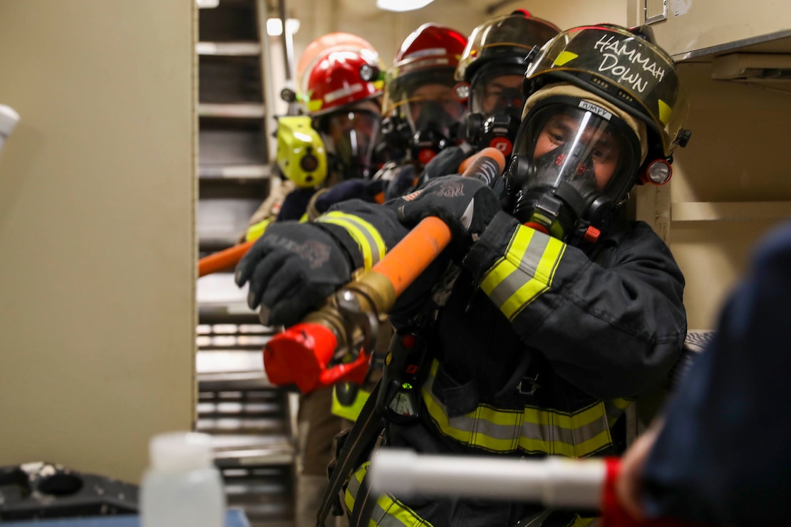 Sailors and Military Sealift Command civilian mariners assigned to the submarine tender USS Emory S. Land (AS 39) conduct a fire drill in coordination with Joint Region Marianas and Guam fire departments, Feb 1.