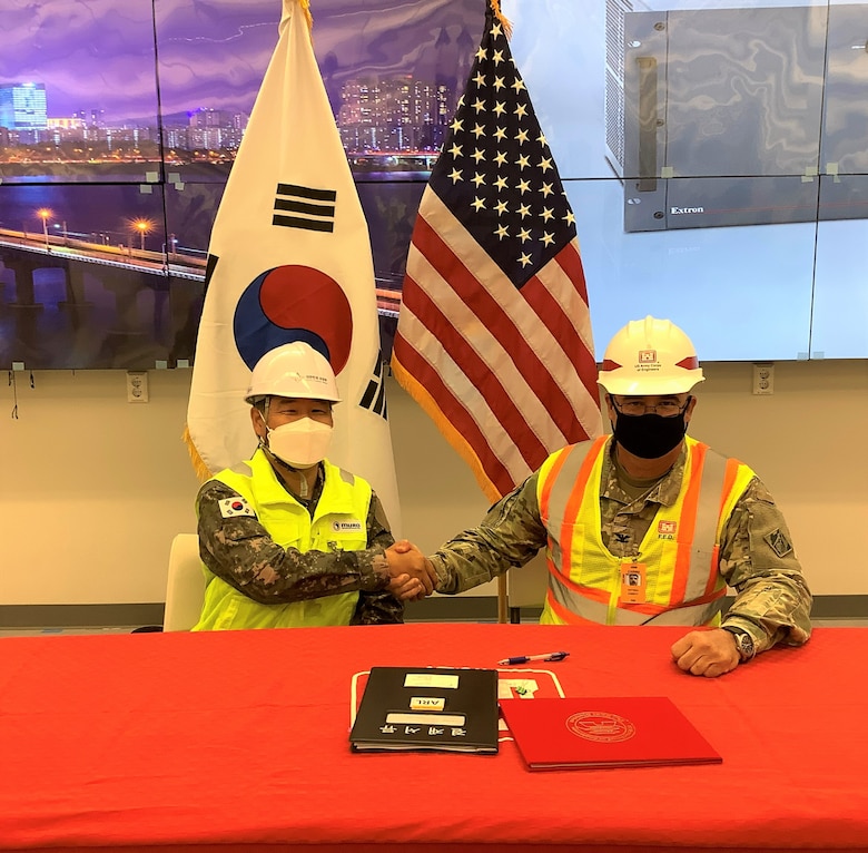 Col. Pyo InTae (left), ROK Design and Construction Agent, shakes hands with Col. Garrett Cottrell (right), Deputy Commanding Officer – Transformation and U.S. Design and Construction Agent, after signing the Acceptance Release Letter for the Command Center Humphreys (project C4I080), at USAG Humphreys, Republic of Korea, April 14. The ceremony signifies a milestone in a project, where the U.S. government accepts the substantially completed facility from the ROK government. (Courtesy photo)