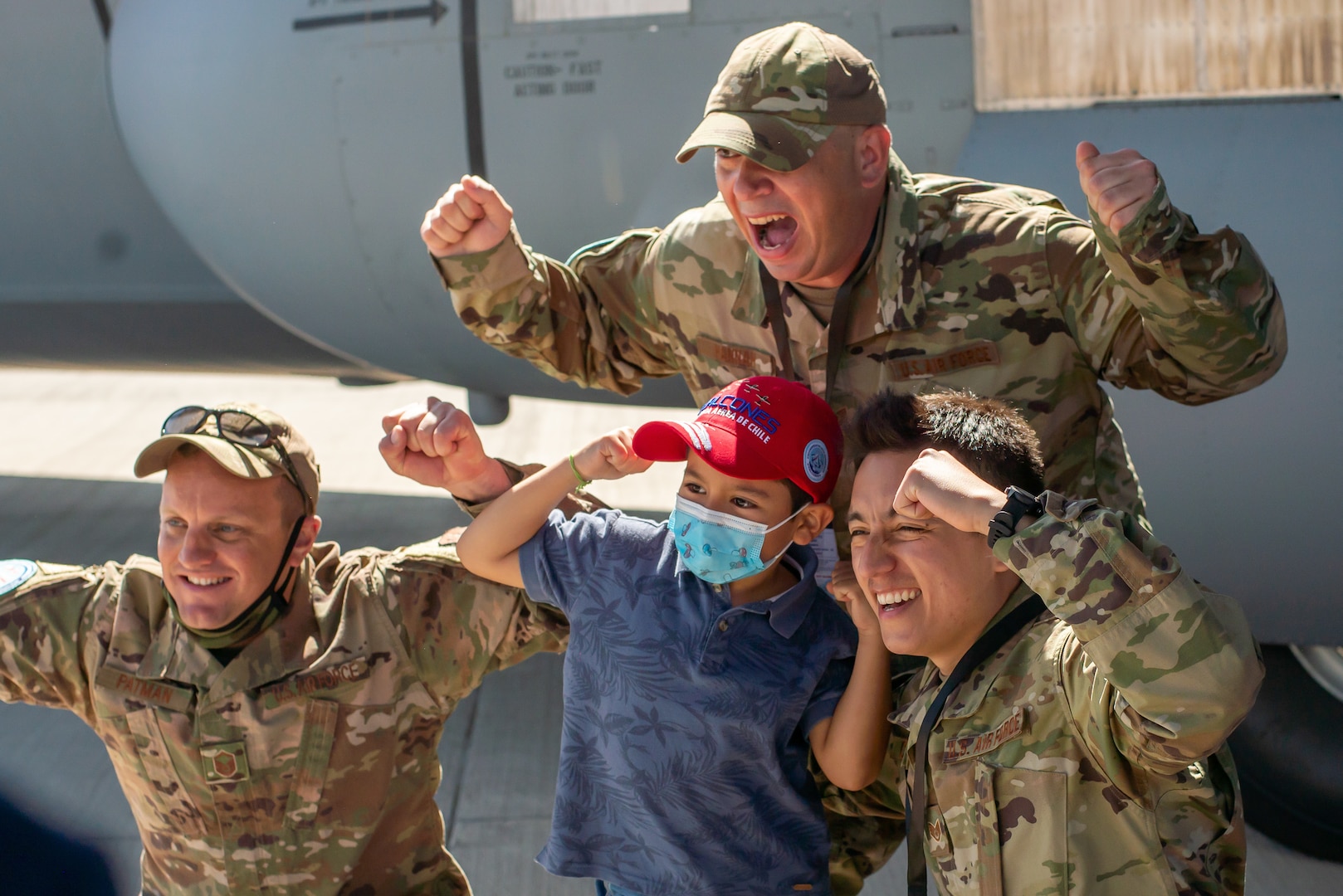 Texas Air National Guard Master Sgt. Jarrett Patman, left, Tech. Sgt. Kevin Hannah, middle, and Staff Sgt. Ivan Castañeda, right, take photos with the public by the C-130J Super Hercules static display at the Feria Internacional del Aire y Espacio (FIDAE) April 9, 2022, in Santiago, Chile. Airmen from the 136th Airlift Wing were available to shepherd tours and answer questions throughout the week of the airshow in an effort to strengthen international partnerships.