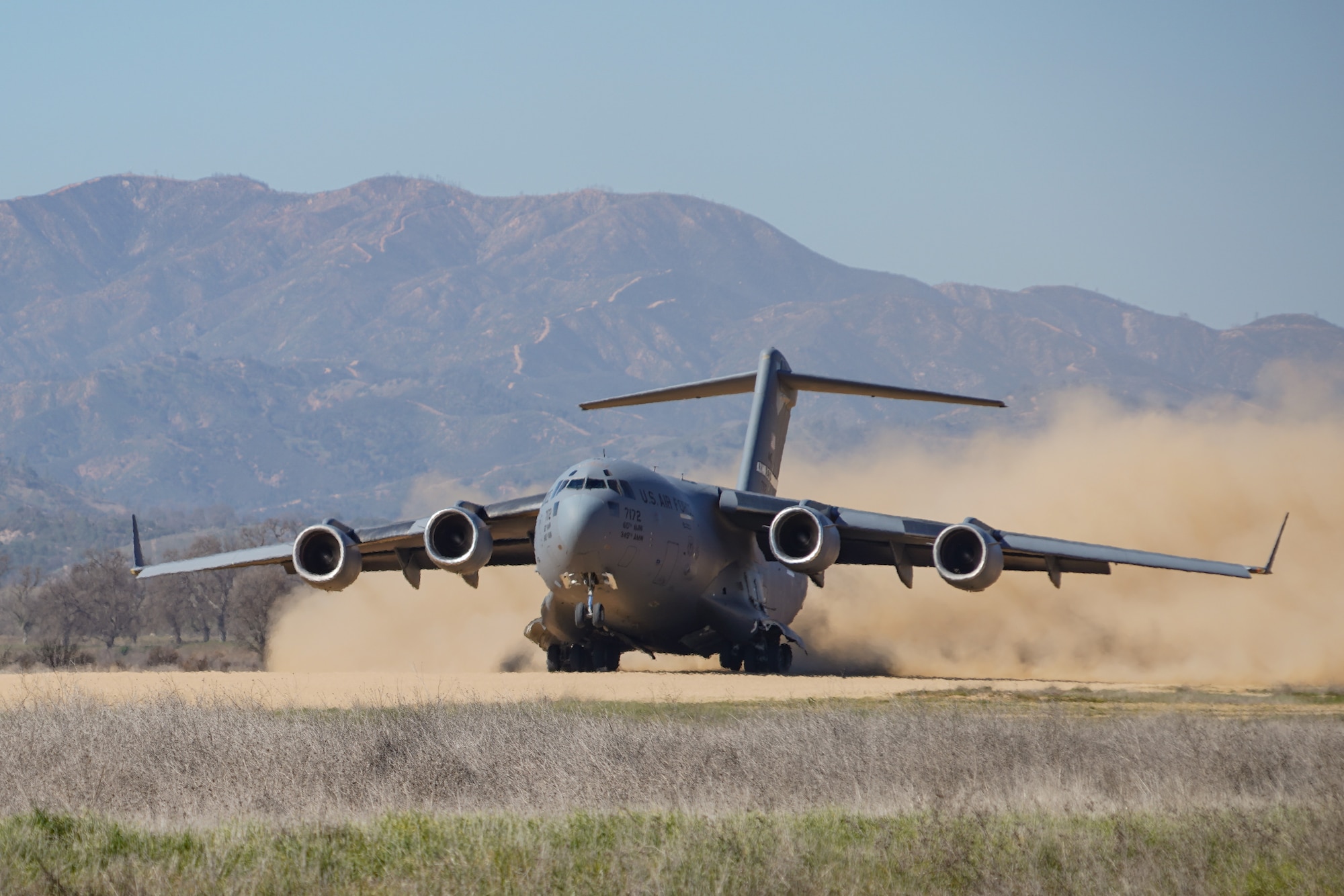 A U.S. Air Force C-17 assigned to the 21st Airlift Squadron departs on an improvised dirt runway at Fort Hunter Liggett, California, Feb. 8, 2022. The 146th Contingency Response Flight and the 621st Contingency Response Wing partnered to accomplish skill-enhancing training and provide airlift support to the 621 CRW's evaluated exercise.