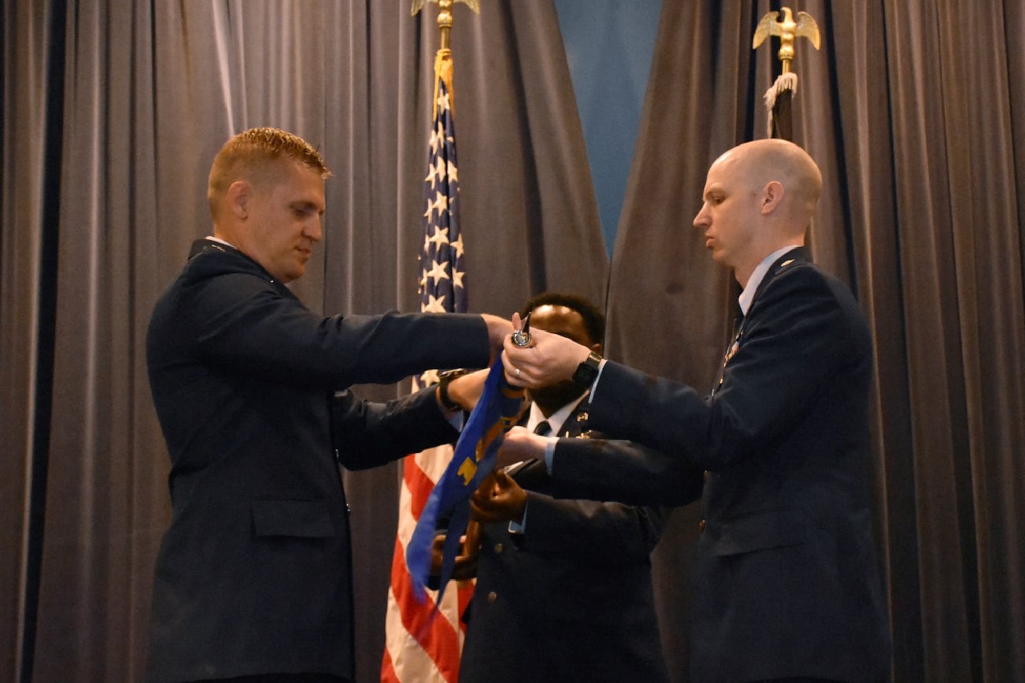 U.S. Space Force Lt. Col. Matthew Lintker, 18th Space Defense Squadron commander, left, U.S. Space Force Lt. Col. Jonathan Smith, special assistance to the Space Delta 2 commander, right, and Tech. Sgt. Anthony Childers, 19 SDS orbital analyst, furl a flag during a ceremony at Naval Support Facility Dahlgren, Va.,  April 6, 2022, that saw the deactivation of the 18th Space Control Squadron Detachment One and the activation of the 19th Space Defense Squadron. The 19 SDS is responsible for providing continuous Space Domain Awareness (SDA) for government, civilian, and international users and to maintain continuous and transparent SDA to assure global freedom of action in space. The 19 SDS and the 18 SDS were officially activated April 13. (U.S. Navy photos by CSSN Mariana Gonzalez)