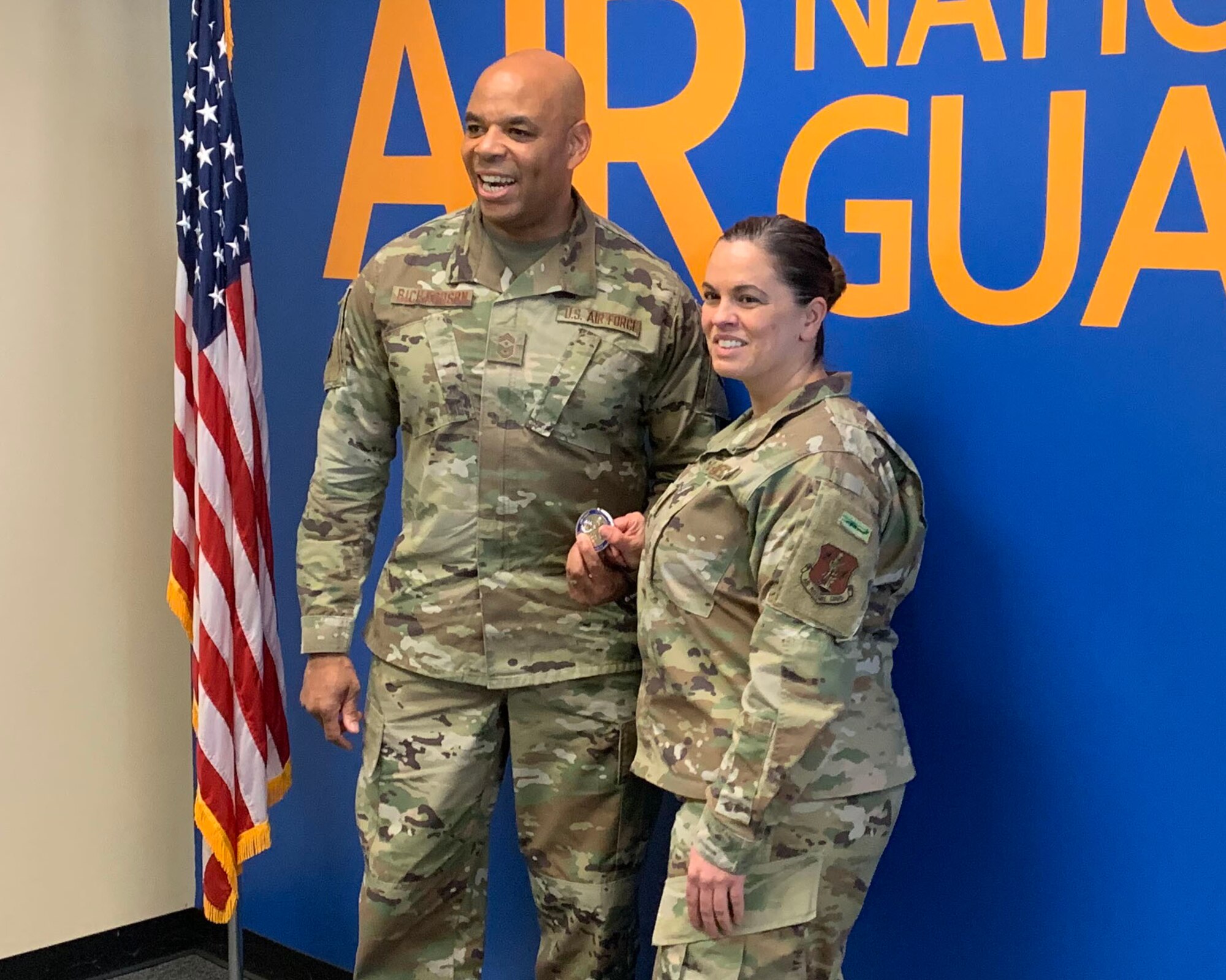 Chief Master Sgt. Denny L. Richardson, New York State Command Chief, presents a challenge coin to Master Sgt. Laurie Perno, 106th Rescue Wing retention office manager, for her work as a recruiter and retention officer at Francis S. Gabreski ANGB, Westhampton Beach, N.Y., April 8, 2022. Perno has recruited 272 Airmen during her career and was ranked the number one retention office manager in New York State for fiscal year 2018, 2019 and 2020. In fiscal year 2019, she was ranked the number six retention office manager in the nation then ranked fourth in the nation fiscal year 2020. (U.S. Air National Guard photo by Lt. Cheran A. Campbell)