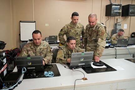 U.S. Airmen with the 156th Combat Communications Squadron, Puerto Rico Air National Guard, configure the network router, switch and phones to establish initial communications during Exercise Tropic Thunder at Camp Santiago Joint Training Center, Puerto Rico, April 11, 2022. Exercise Tropic Thunder is the first large-scale exercise for the 156th CBCS to build and maintain network functions from the ground up, to meet initial operational requirements while developing the cyber skills and teamwork required to operate in any combat communications environment.