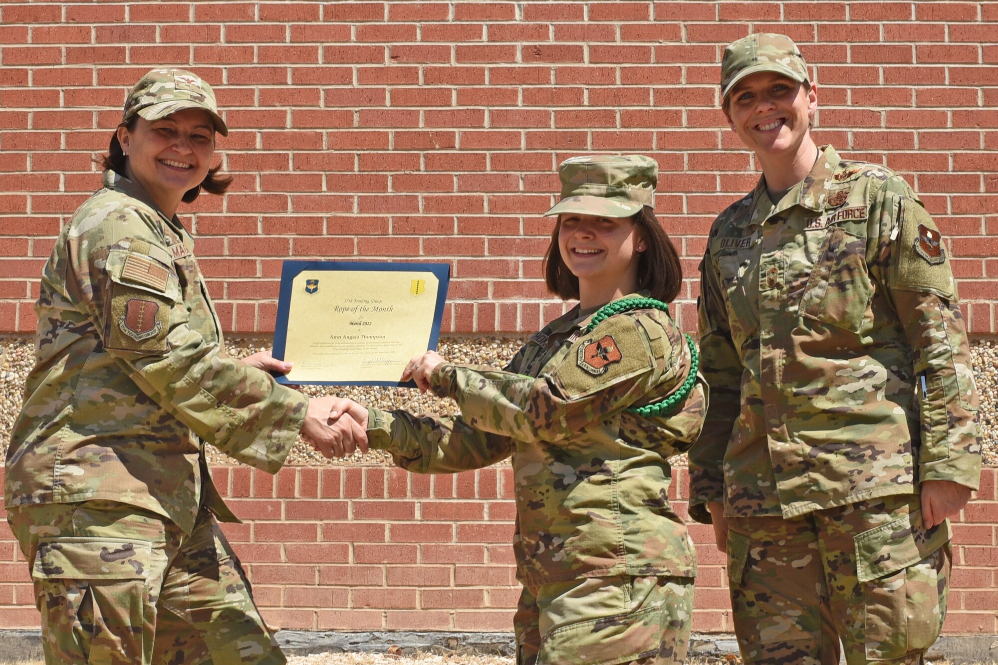 U.S. Air Force Col. Angelina Maguinness, 17th Training Group commander, and Chief Master Sgt. Breana Oliver, 17th TRG superintendent, present Airman Angela Thompson, 315th Training Squadron student, the 17th TRG Rope of the Month award for March 2022, Goodfellow Air Force Base, Texas, April 15, 2022. The 315th TRS’s mission is to train, educate and inspire the future intelligence, surveillance and reconnaissance warriors. (U.S. Air Force photo by Senior Airman Abbey Rieves)