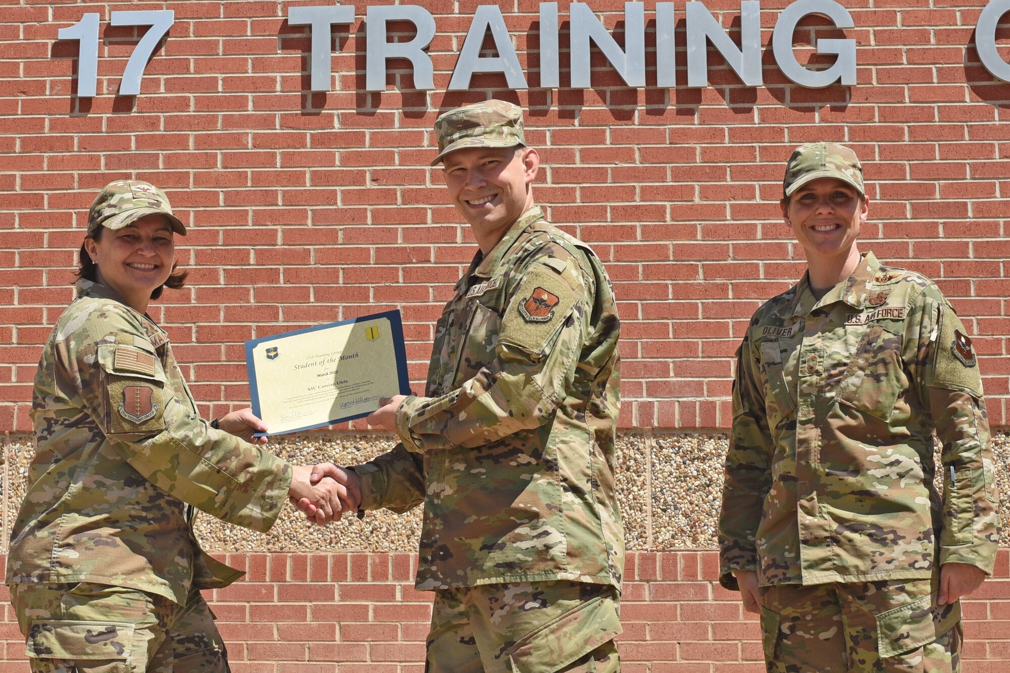 U.S. Air Force Col. Angelina Maguinness, 17th Training Group commander, and Chief Master Sgt. Breana Oliver, 17th TRG superintendent, present Airman 1st Class Cassian Utrie, 315th Training Squadron student, a 17th TRG Student of the Month award for March 2022, Goodfellow Air Force Base, Texas, April 15, 2022.  Utrie worked hard for his award and has shown his dedication to his squadron and the training he received at Goodfellow. (U.S. Air Force photo by Senior Airman Abbey Rieves)