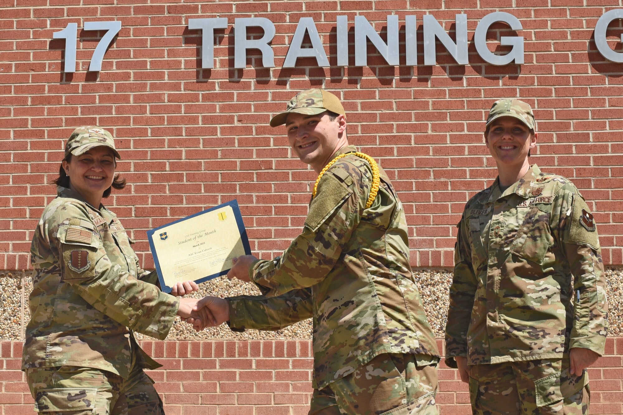 U.S. Air Force Col. Angelina Maguinness, 17th Training Group commander, and Chief Master Sgt. Breana Oliver, 17th TRG superintendent, present Airman 1st Class Even Calvert, 17th TRG student, a 17th TRG Student of the Month award for March 2022, Goodfellow Air Force Base, Texas, April 15, 2022.  Calvert worked hard for his award and has shown his dedication to his squadron and the training he received at Goodfellow. (U.S. Air Force photo by Senior Airman Abbey Rieves)