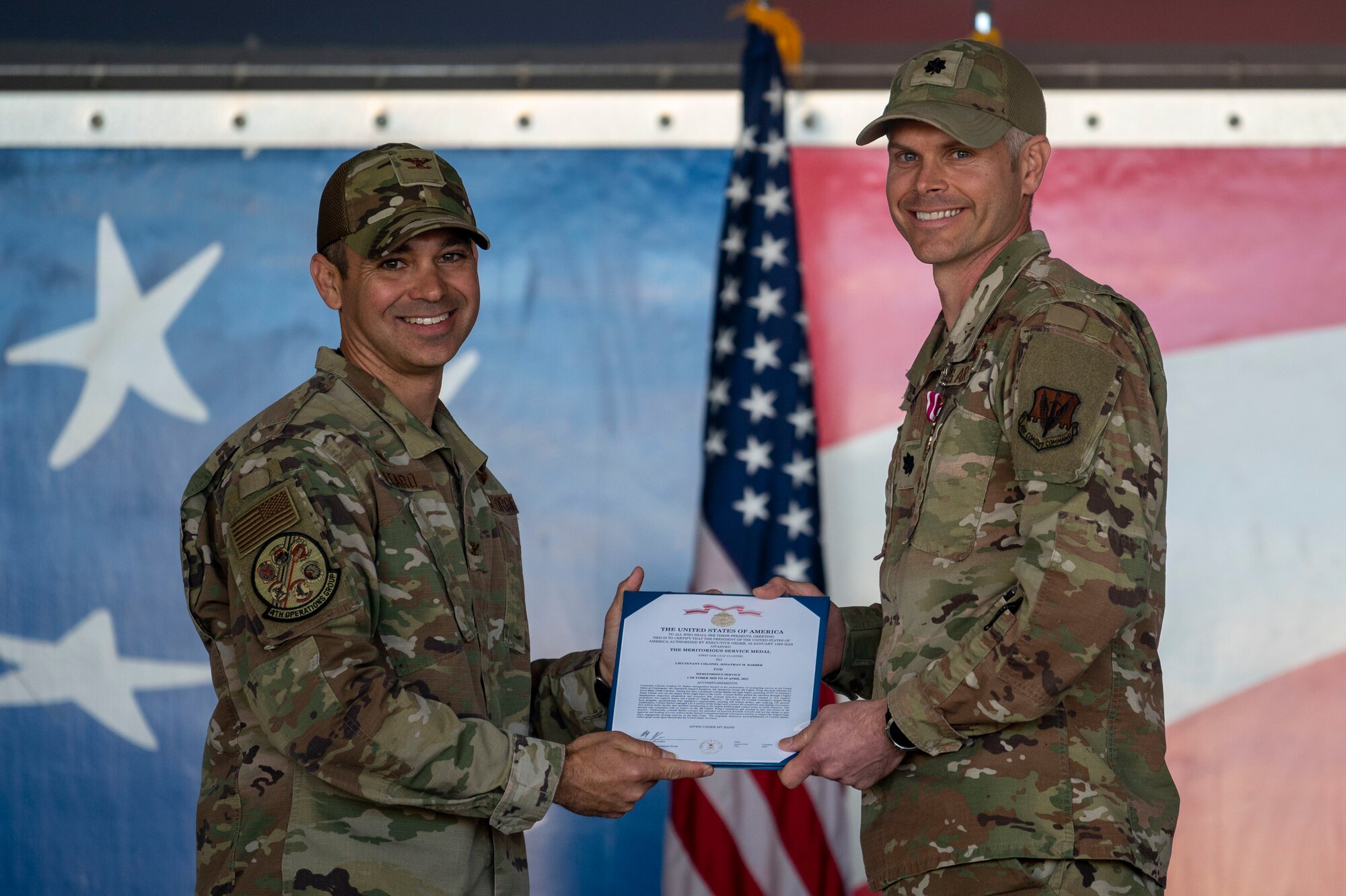 Lt. Col. Jonathan Barber, right, outgoing 4th Operational Support Squadron commander, receives the Meritorious Service Medal during the 4th OSS change of command ceremony at Seymour Johnson Air Force Base, North Carolina, April 15, 2022. The Meritorious Service Medal is awarded to members of the armed services who distinguish themselves by outstanding service to the United States. (U.S. Air Force photo by Senior Airman Kevin Holloway)