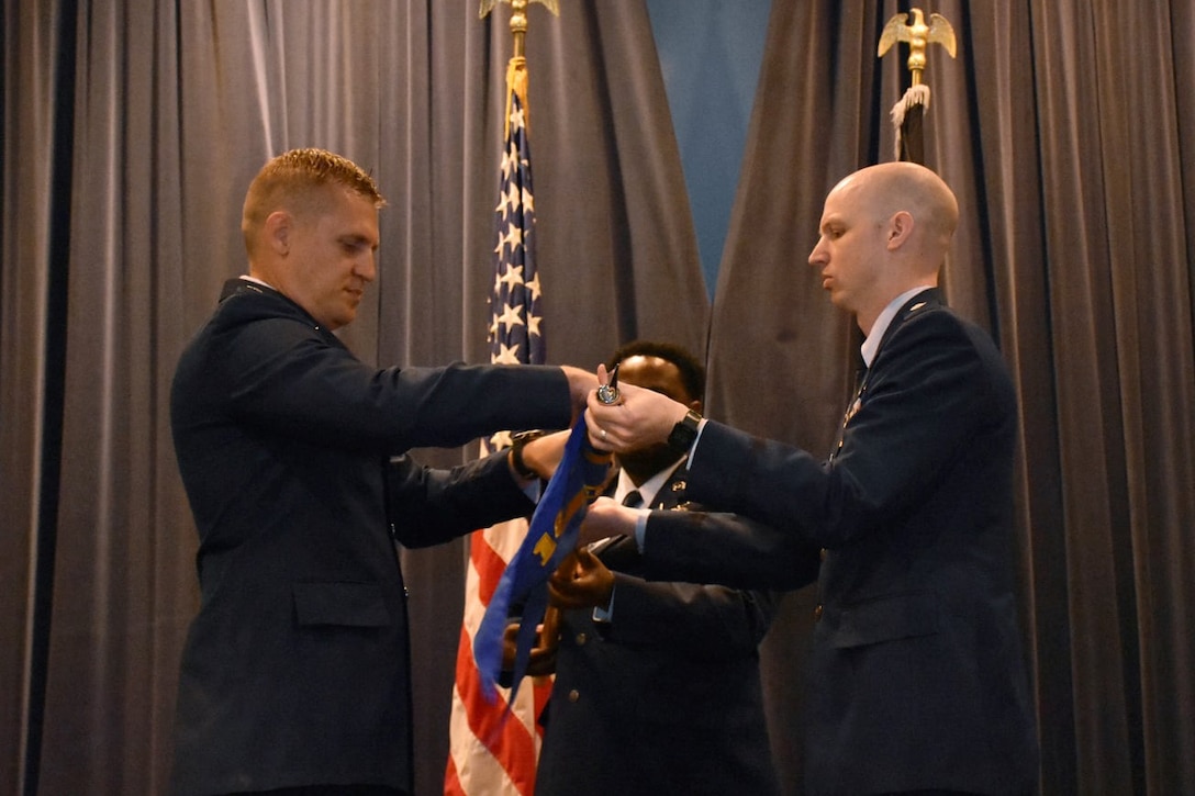 U.S. Space Force Lt. Col. Matthew Lintker, 18th Space Defense Squadron commander, left, U.S. Space Force Lt. Col. Jonathan Smith, special assistance to the Space Delta 2 commander, right, and Tech. Sgt. Anthony Childers, 19 SDS orbital analyst, furl a flag during a ceremony at Naval Support Facility Dahlgren, Va.,  April 6, 2022, that saw the deactivation of the 18th Space Control Squadron Detachment One and the activation of the 19th Space Defense Squadron. The 19 SDS is responsible for providing continuous Space Domain Awareness (SDA) for government, civilian, and international users and to maintain continuous and transparent SDA to assure global freedom of action in space. The 19 SDS and the 18 SDS were officially activated April 13. (U.S. Navy photos by CSSN Mariana Gonzalez)