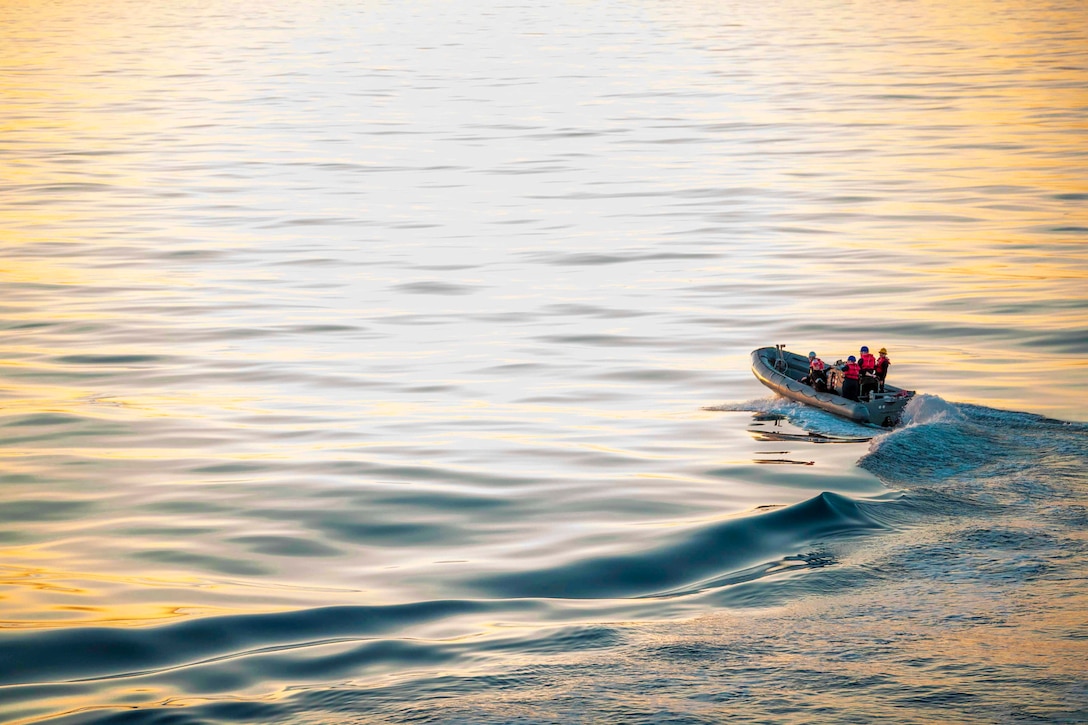 Sailors travel through waters in a small inflatable boat.
