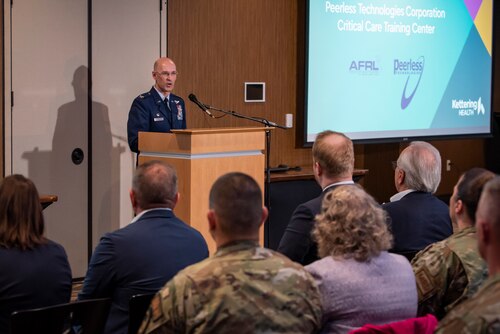 Col. Tory Woodard, center, commander, U.S. Air Force School of Aerospace Medicine, makes a speech during the official opening of the Enlisted Critical Care Course (EECC) at the Soin Medical Center April 13, 2022, in Beavercreek, Ohio. USAFSAM is one of two mission units in the 711th Human Performance Wing, part of the Air Force Research Laboratory (AFRL). AFRL and Kettering Health Network partnered to create a training wing at Soin Medical Center, which allows the Air Force to received training as critical care technicians and also give back to the community. There are 10 courses in a year with 10 technicians each, and the four-week course provides didactics, lectures, simulations and real-patient care. (U.S. Air Force photo / Richard Eldridge)