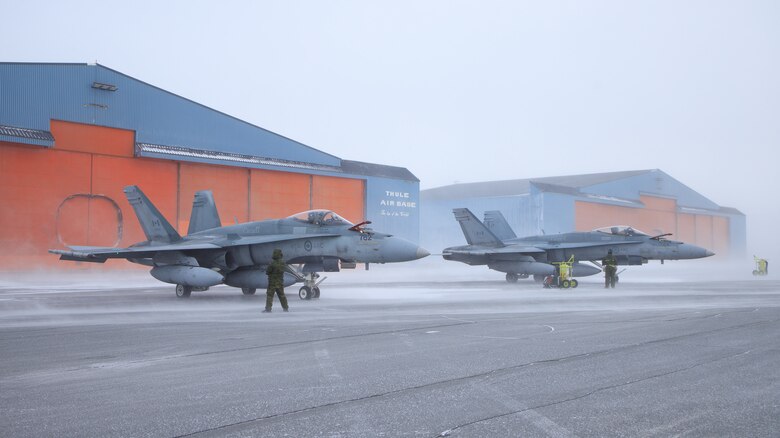 Two Royal Canadian Air Force CF-18 Hornets await flying missions during Operation NOBLE DEFENDER at Thule Air Base, Greenland, March 15, 2022.