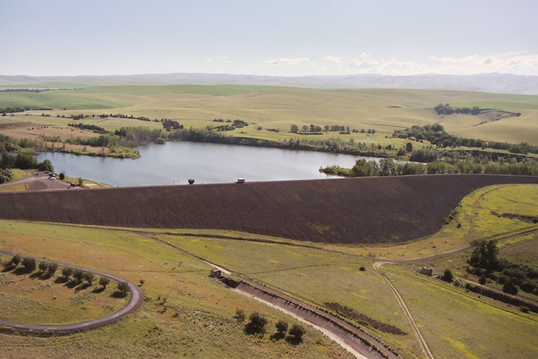 The dam is an earthfill structure with a heavy gravel face located in a drainage off of Mill Creek. The dam is 800 feet wide at the base, 125 feet high, 20 feet wide at the top and 3,200 feet long at the crest. A 2260 foot long concrete cutoff wall extends 2 feet into bedrock.