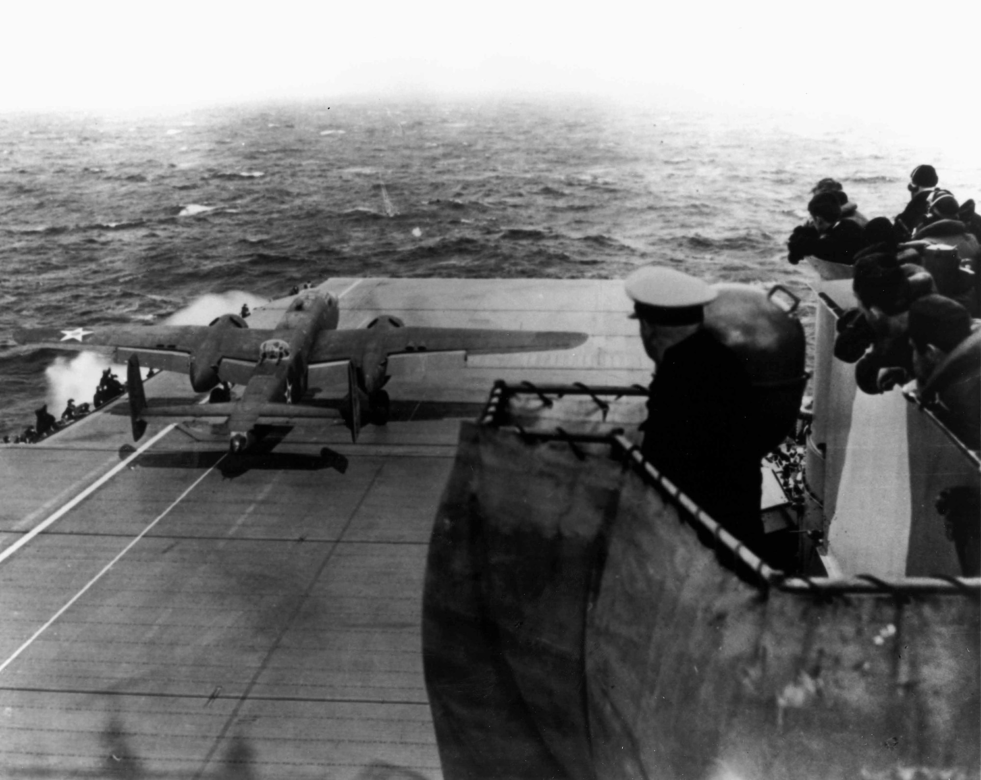 A modified B-25B Mitchell medium bomber takes off from the US Navy aircraft carrier USS Hornet (CV-8) to attack the Home Islands of Imperial Japan on April 18, 1942, about 170-miles short of their planned takeoff point after the carrier task force was spotted by an enemy patrol ship.  The bombers launched earlier than desired but for the most part managed to hit their assigned targets.  Then after 13 hours in the air the crews crash-landed or bailed out in various places in China as they made their way from Japan – the only intact aircraft was one B-25 which landed in the Soviet Far East and was interned with its crew by the Soviets.  None of the bombers were shot down by enemy fighters or anti-aircraft fire. (Photo courtesy of 28th Bomb Wing Historian’s office)