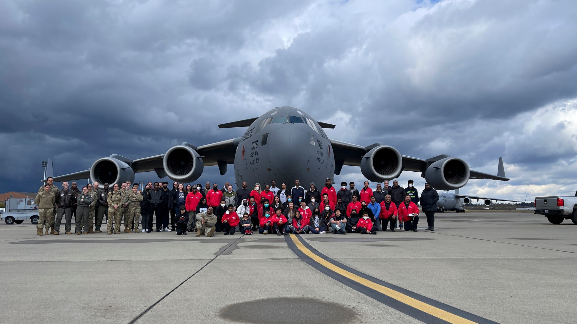 Members of the Red-Tailed Hawks Youth Program pose for a photo in front of a C-17 Globemaster III during the Aviation Inspiration and Mentorship (AIM) Wing event at Joint Base Lewis-McChord, Washington, April 16, 2022. AIM Wing is an community outreach program with a mission to inform, influence and inspire the next generation of Air Force aviators. (U.S. Air Force photo by Airman 1st Class Charles Casner)