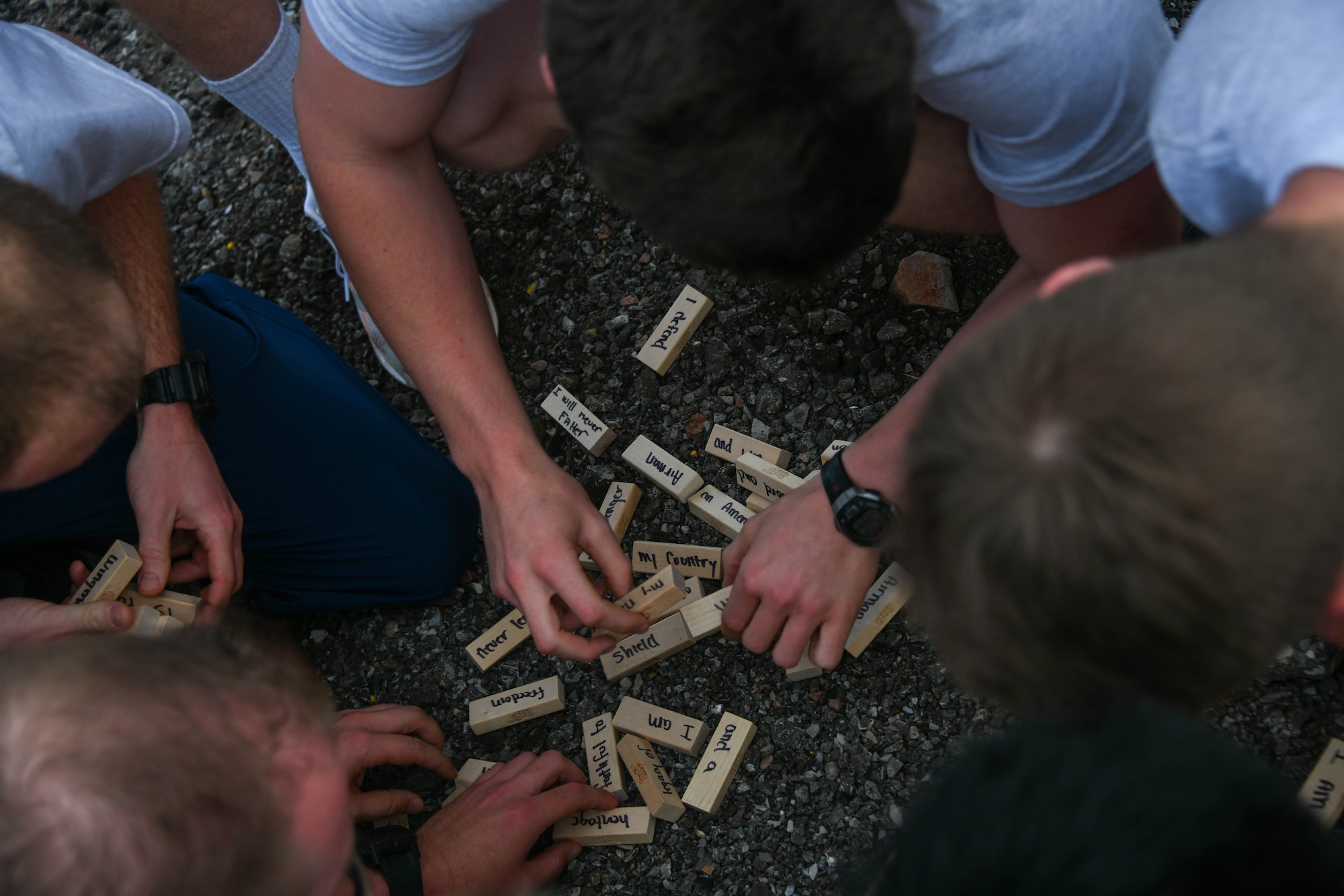 97th Training Squadron students construct the Airman’s creed with blocks at the Talon Challenge at Altus Air Force Base, Oklahoma, April 10, 2022. The events at the Talon Challenge included a buddy drag, a prisoners of war/missing in action table, an Airman’s Creed exercise, Airmanship lessons and sexual assault awareness training. (U.S. Air Force photo by Airman 1st Class Trenton Jancze)