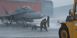 Royal Canadian Air Force crew chiefs conduct towing procedures for a CF-18 Hornet during Operation NOBLE DEFENDER at Thule Air Base, Greenland, March 16, 2022.