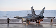 A servicemember guides a Royal Canadian Air Force CF-18 Hornet into the hangar upon arrival at Thule Air Base, Greenland, for Operation NOBLE DEFENDER, March 14, 2022.