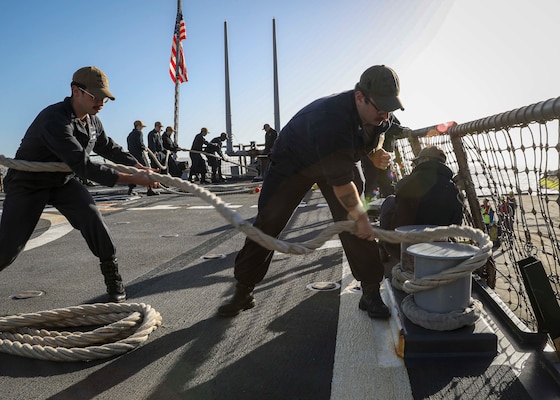 Sonar Technician (Surface) 2nd Class Alex Cantrell, center, puts a round turn on a mooring line during a sea and anchor detail aboard the Arleigh Burke-class guided-missile destroyer USS Porter (DDG 78), April 14.