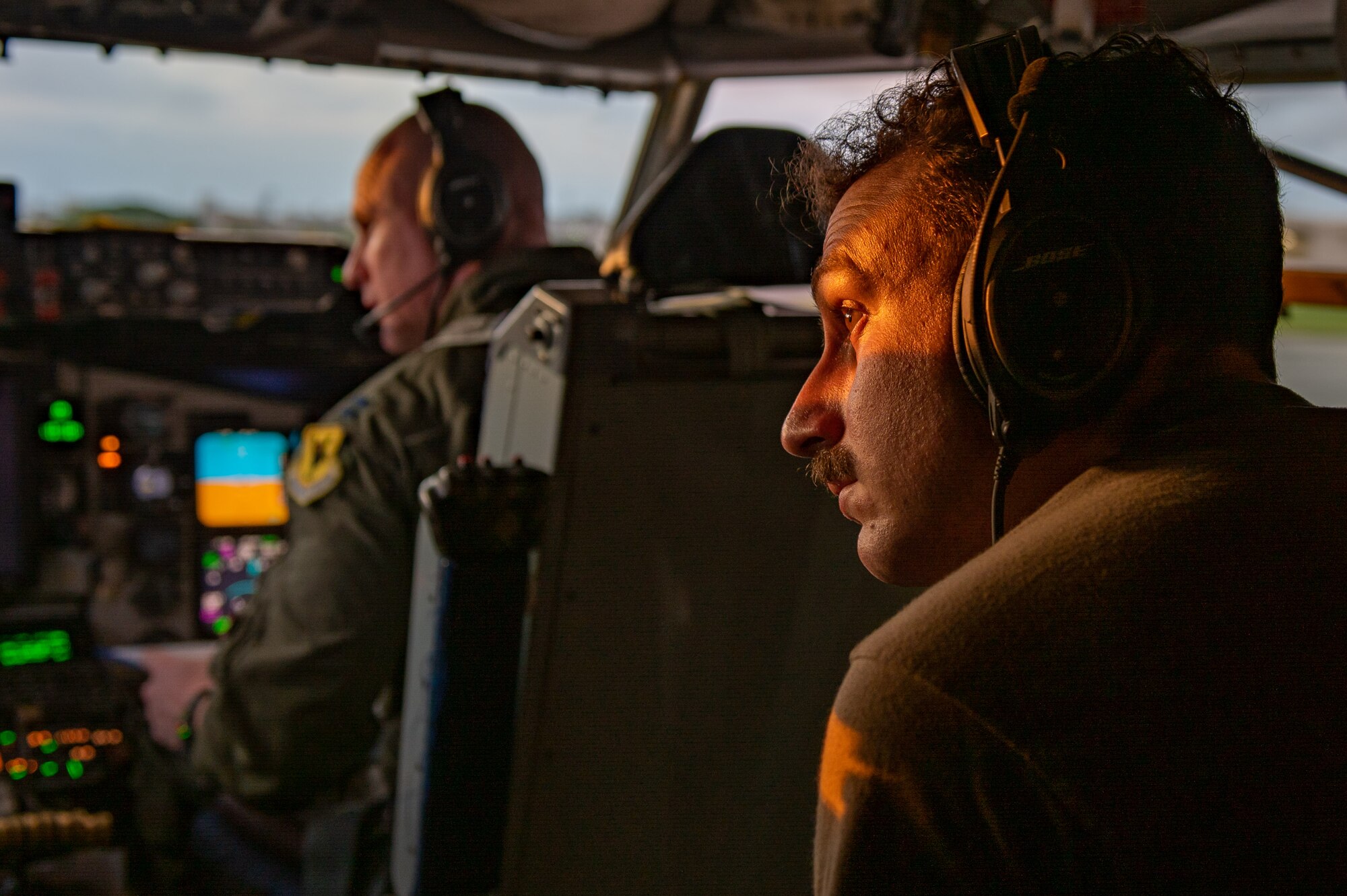 Two airmen watch the sunset as they prepare for takeoff