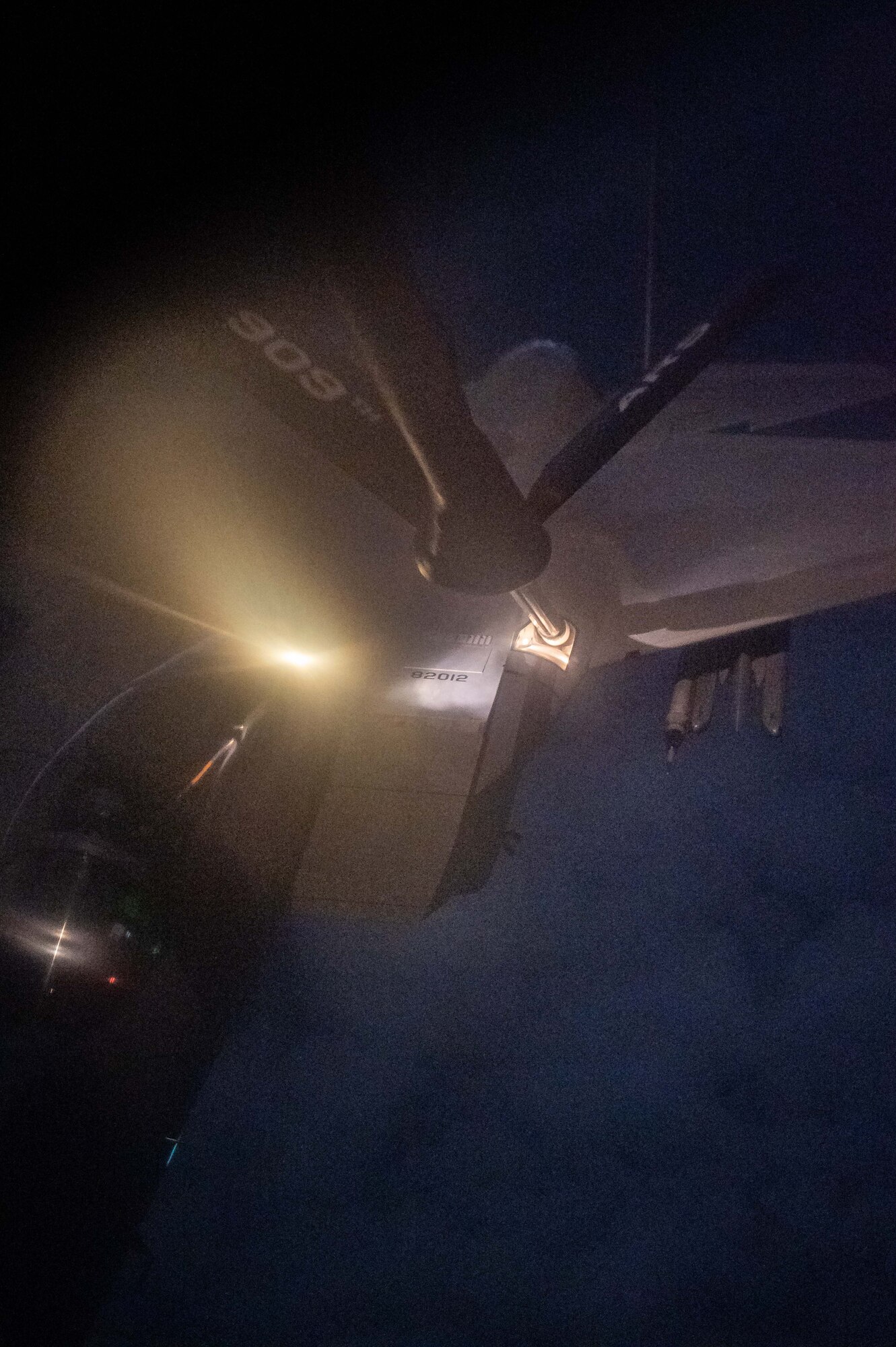 A fighter jet receives fuel from a refueling plane at night