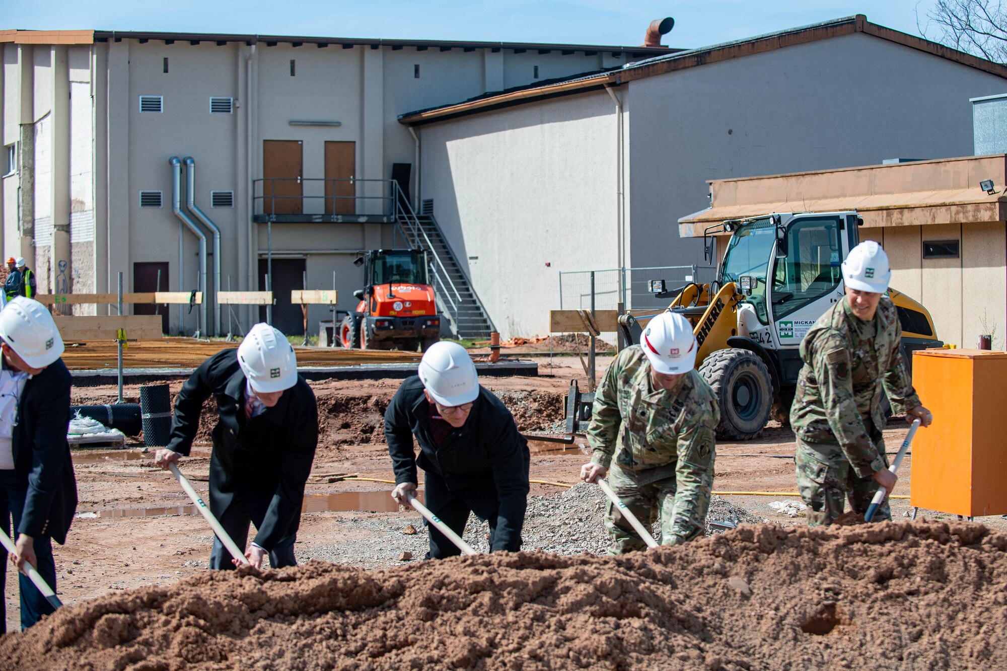 Service members dig at a construction site