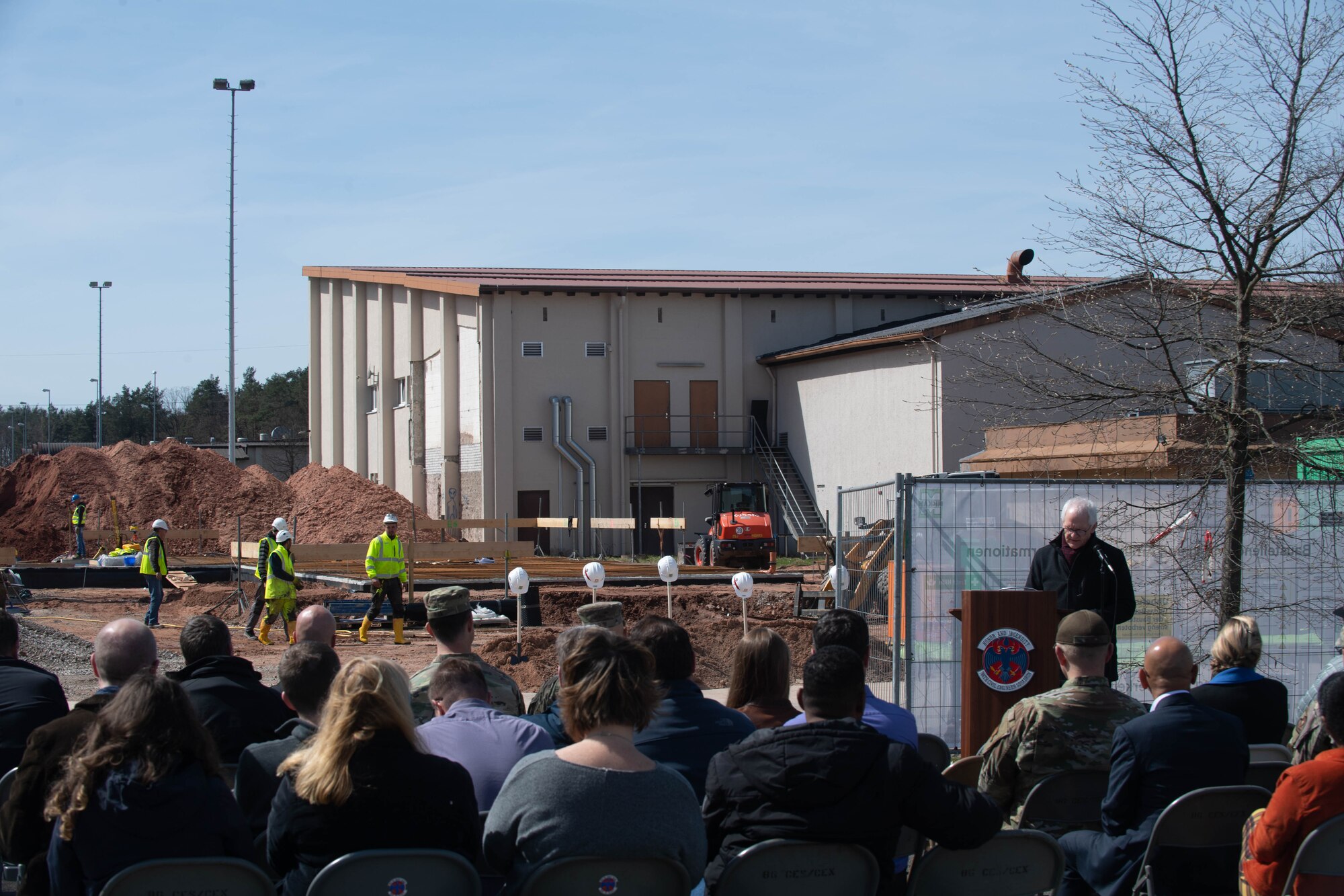 Man speaks in front of a construction site.