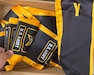 black and yellow fabric graduation stoles folded in a box.