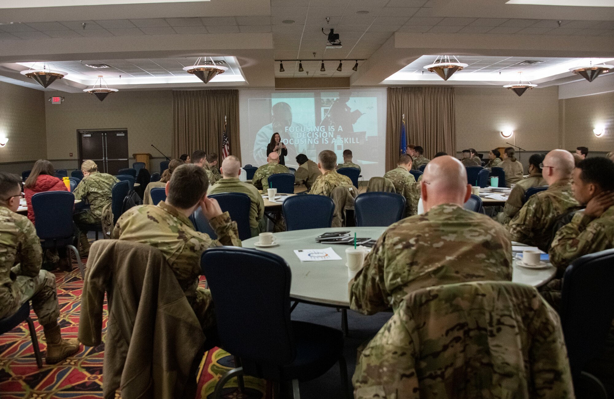 Several Airmen face forward and watch intently as they are briefed.