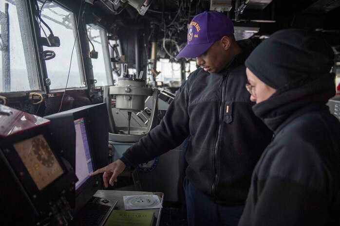 Ensign Ferando Violenvsellis, left, and Ensign Sarah Mccann, monitor data during a maneuvering drill aboard the Whidbey Island-class dock landing ship USS Gunston Hall (LSD 44), Jan. 21, 2021.