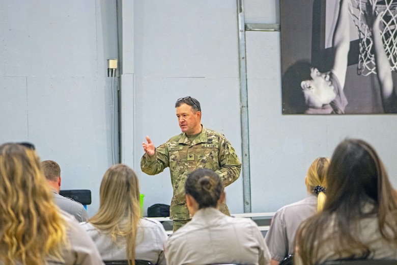 Man in army uniform talks to park rangers