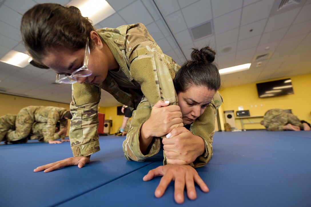 An airman tries to escape from a rear mount of a fellow service member during training.