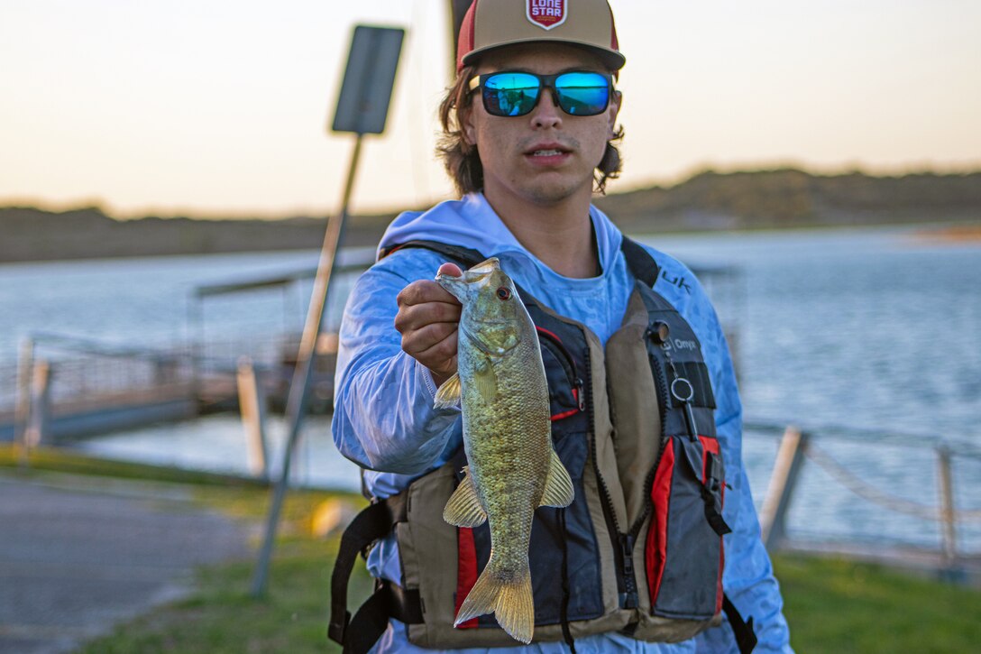 Person stand holding a fish