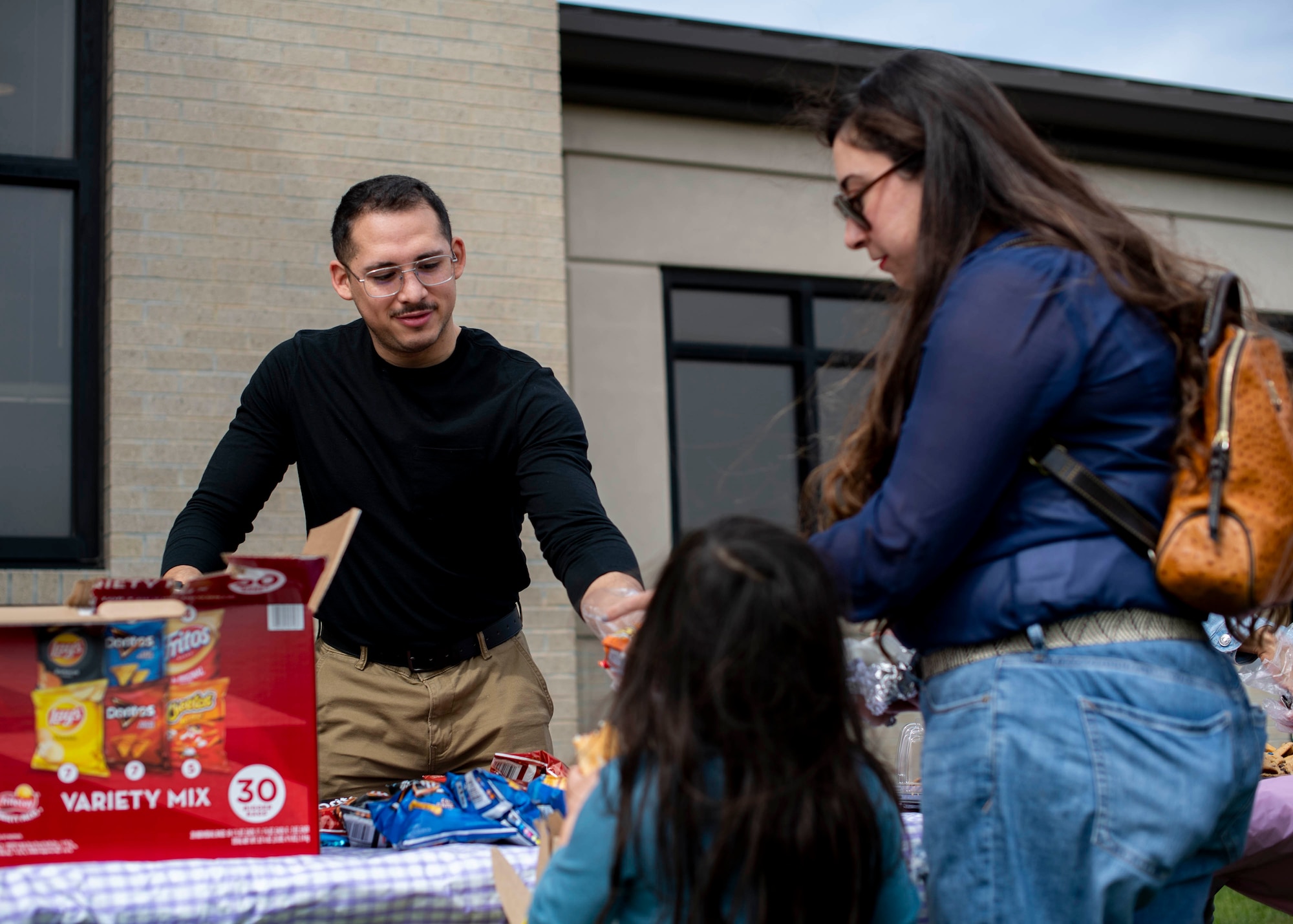 Senior Airman Benito Reina, 436th Airlift Wing religious affairs member, hands out snacks during the Easter Egg-stravaganza at Dover Air Force Base, Delaware, April 16, 2022. Hosted by the Dover AFB Chaplain Corps and the USO, the event featured a bounce house and slide, Easter egg hunt, free food and raffle. (U.S. Air Force photo by Tech. Sgt. J.D. Strong II)