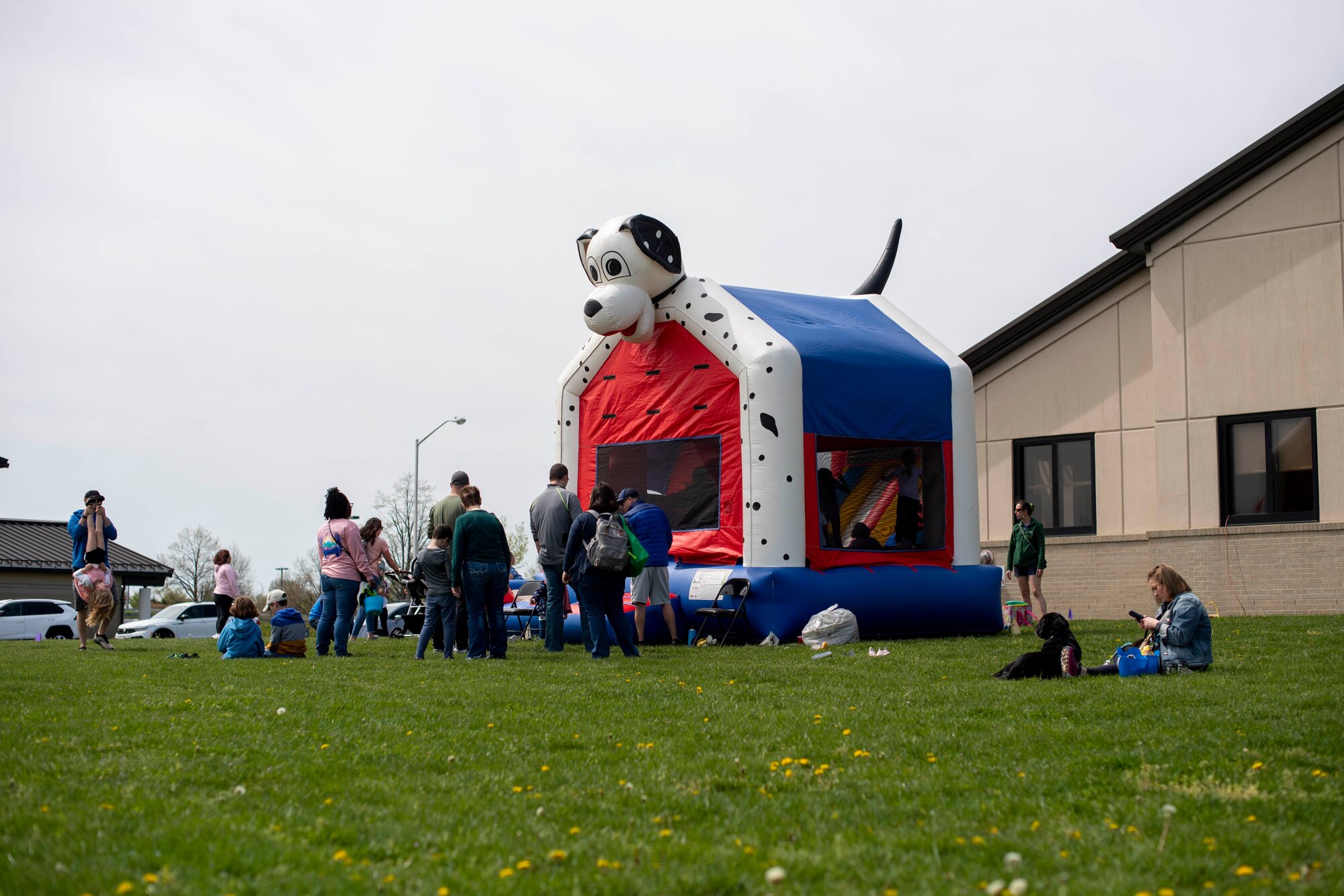 Members of Team Dover play in and around a bounce house during the Easter Egg-stravaganza at Dover Air Force Base, Delaware, April 16, 2022. Hosted by the Dover AFB Chaplain Corps and the USO, the event also featured an inflatable slide, Easter egg hunt, free food and raffle. (U.S. Air Force photo by Tech. Sgt. J.D. Strong II)