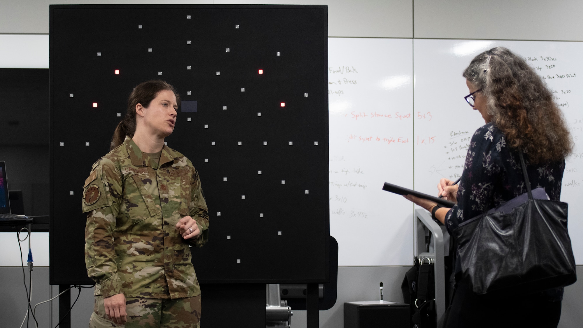 Dr. Wendy Walsh (right), Air Education and Training Command chief learning officer, is briefed by Maj. Jessica Carpenter (left), Special Warfare Human Performance Squadron conditioning flight commander, about tools that help assess and improve neurocognitive reaction times for Air Force Special Warfare candidates at the Special Warfare Training interim Wing Human Performance Training Center at Joint Base San Antonio-Chapman Training Annex, Texas, April 5, 2022. Dr. Walsh and her team participated in an immersion tour of the SWTW to learn about how the SWTW builds Air Force Special Warfare Airmen and prepares them for combat.