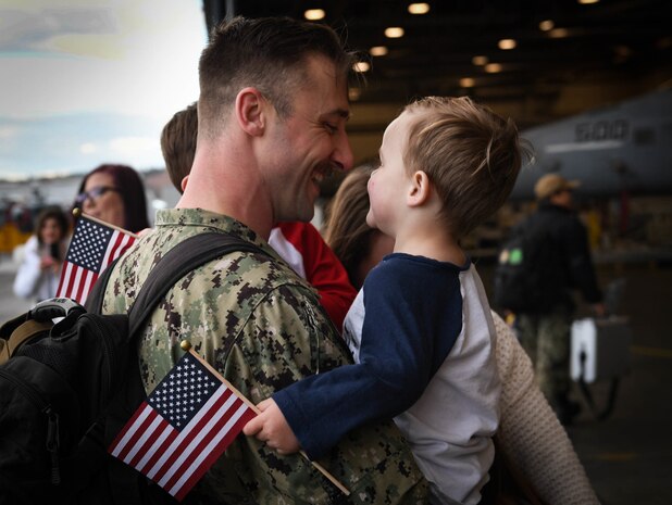 A sailor assigned to the “Gauntlets” of Electronic Attack Squadron (VAQ) 136 greets his family after returning to Naval Air Station Whidbey Island, Washington, Feb 14, following an eight-month deployment to U.S. 3rd and 7th Fleet areas of operations as part of the Carl Vinson Carrier Strike Group.