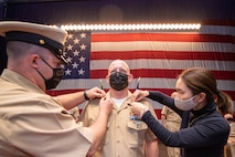 Chief Logistics Specialist Daniel Neal is pinned during a chief petty officer pinning ceremony at Naval Base Kitsap in Bremerton, Washington Nov. 19, 2021. The rank of chief petty officer was officially established April 1, 1893, and holding the title "Chief" means a Sailor has achieved senior non-commissioned officer status.