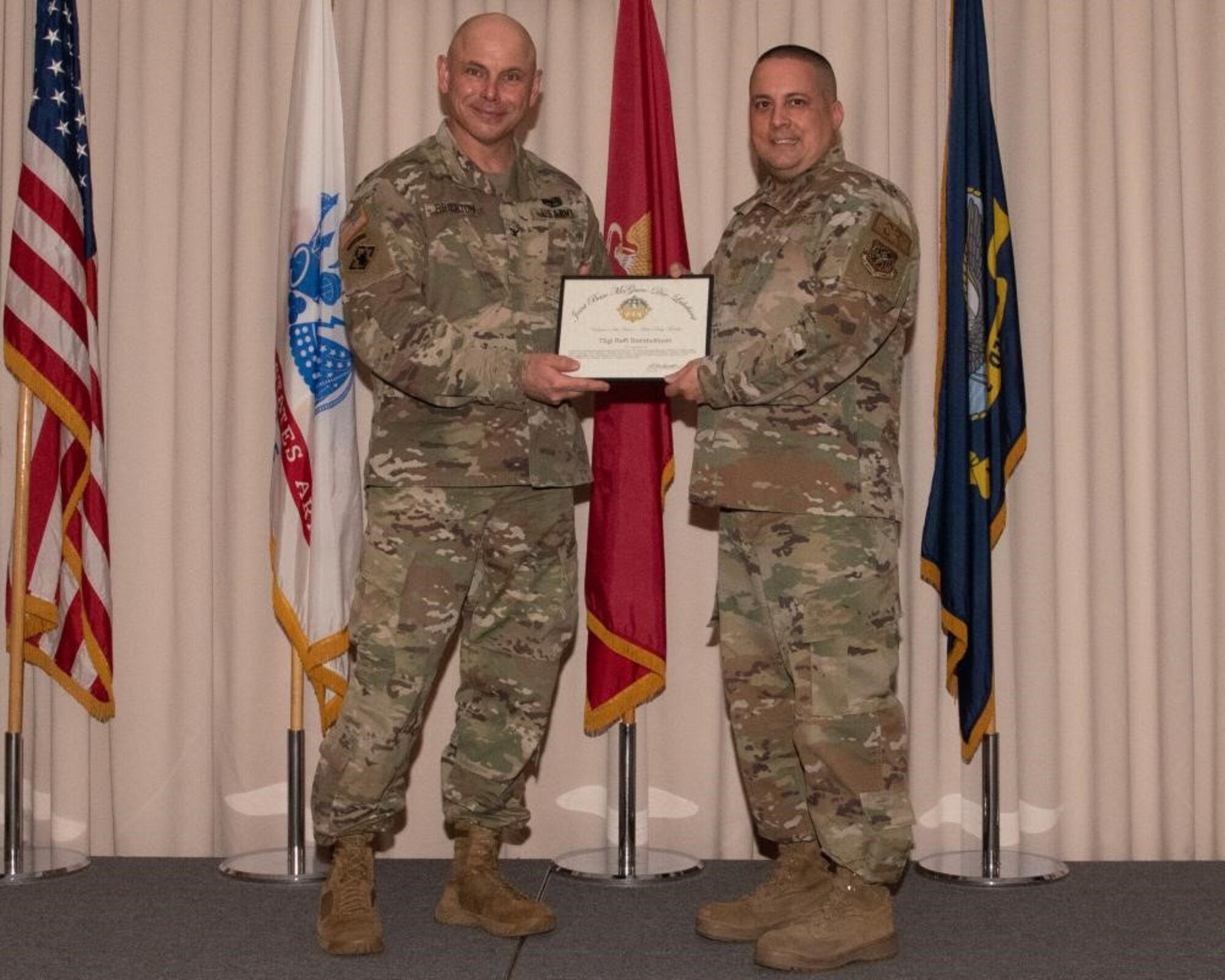U.S. Army Col. Jon Brierton, Army Support Activitiy, Fort Dix Commander and Joint Base McGuire-Dix-Lakehurst, N.J., Deputy Commander, presents award to Chief Master Sgt. Brian Nolan on behalf of Tech. Sgt. Raffi Stambultsyan April 14, 2022 at Tommy B's Community Activities Center. Stambultsyan was recognized as active duty member volunteer of the year.