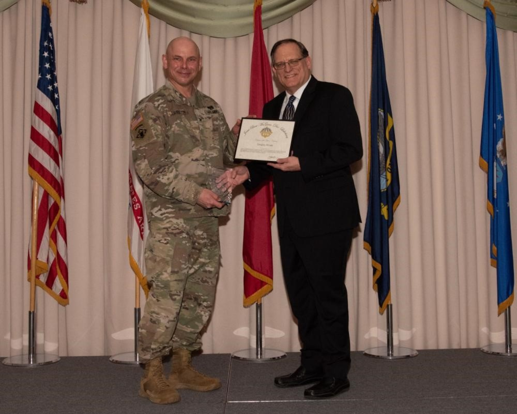 U.S. Army Col. Jon Brierton, Army Support Activitiy, Fort Dix Commander and Joint Base McGuire-Dix-Lakehurst, N.J., Deputy Commander, presents award to Gregory Kruse April 14, 2022 at Tommy B's Community Activities Center. Kruse was recognized as civilian volunteer of the year
