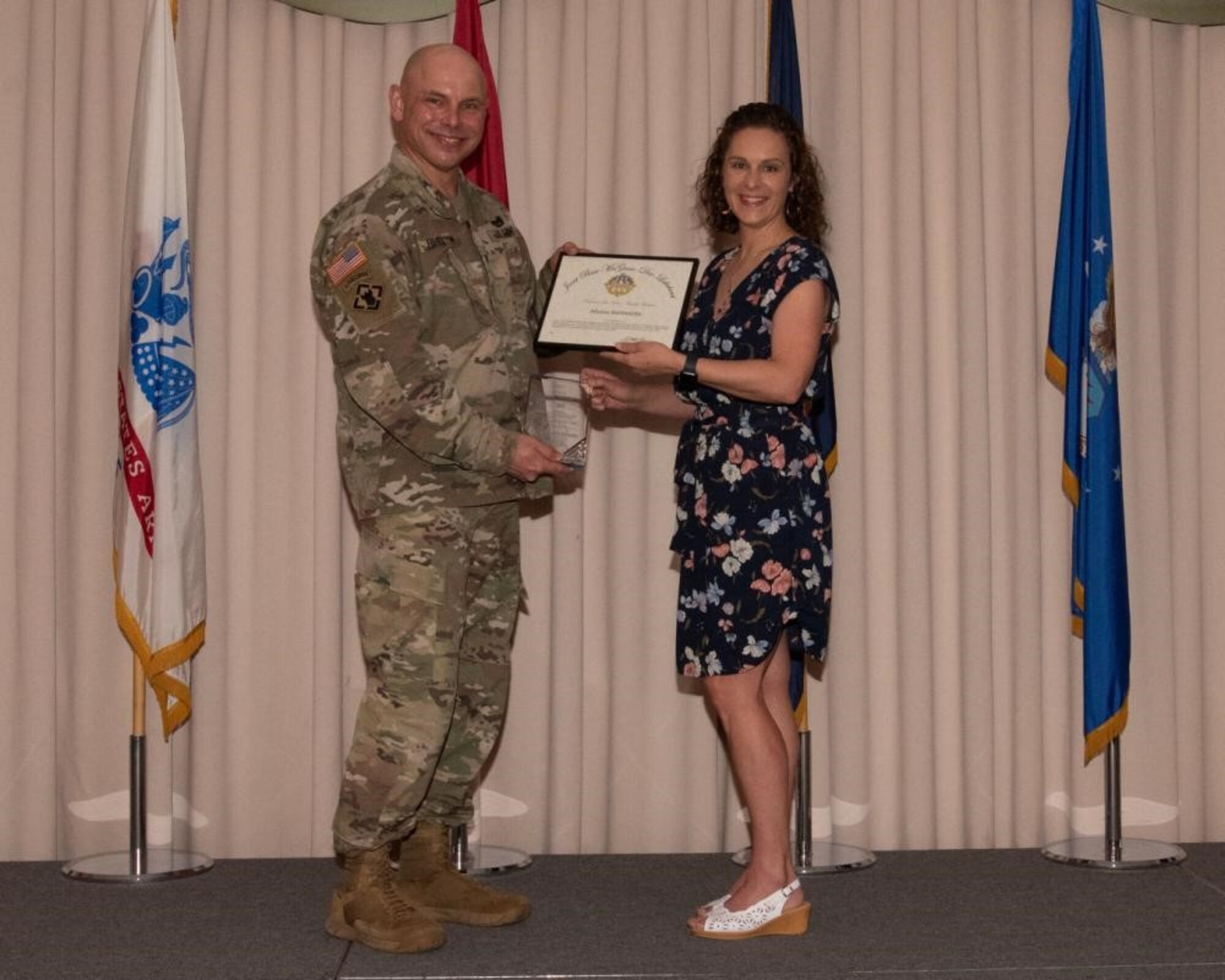 U.S. Army Col. Jon Brierton, Army Support Activitiy, Fort Dix Commander and Joint Base McGuire-Dix-Lakehurst, N.J., Deputy Commander, presents award to Allyssa Berthelotte April 14, 2022 at Tommy B's Community Activities Center. Berthelotte was recognized as family member volunteer of the year.