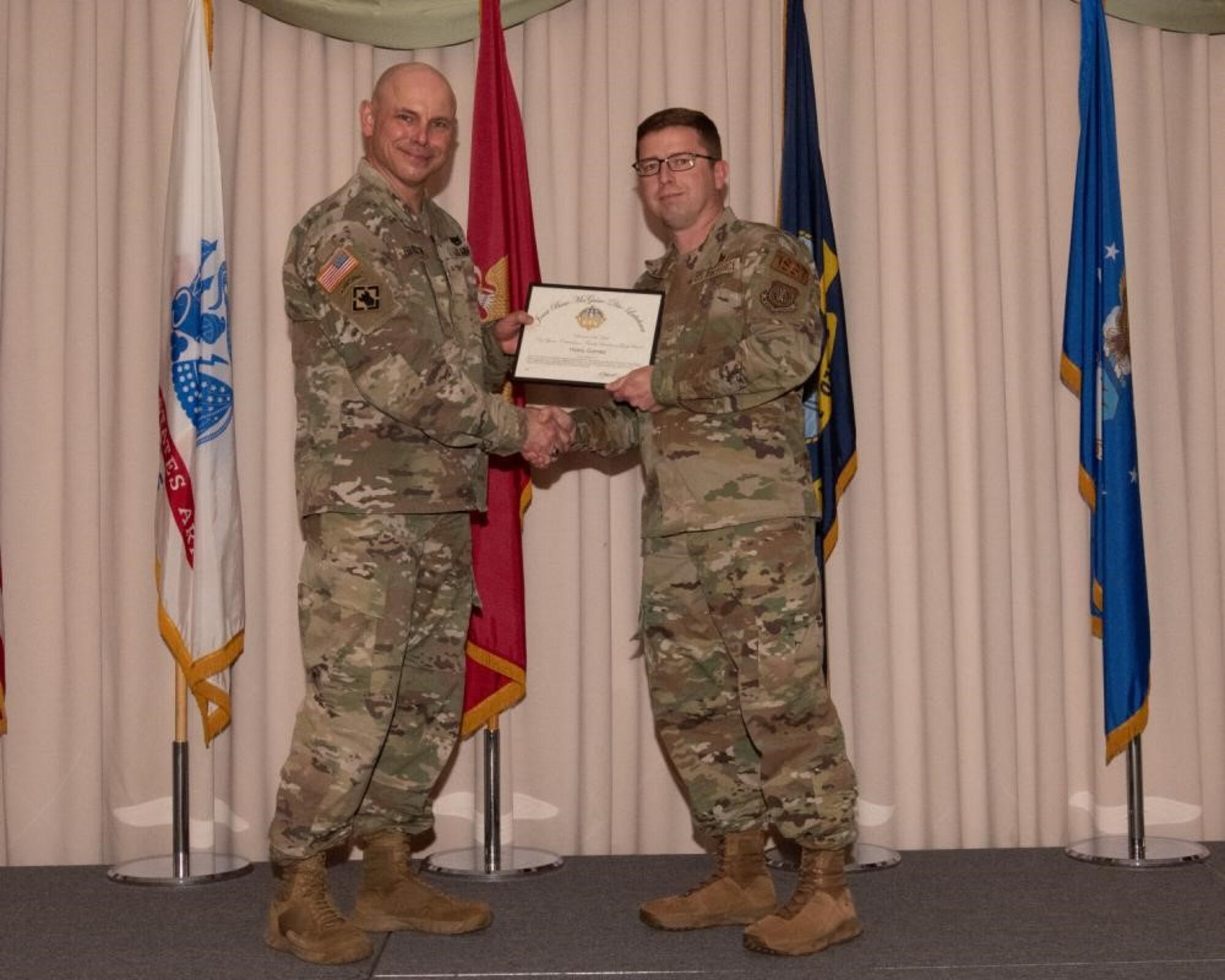 U.S. Army Col. Jon Brierton, Army Support Activitiy, Fort Dix Commander and Joint Base McGuire-Dix-Lakehurst, N.J., Deputy Commander, presents award to Master Sgt. Troy Ramsey on behalf of Haley Gomez April 14, 2022 at Tommy B's Community Activities Center. Gomez was recognized as key spouse, ombudsman, family readiness group leader volunteer of the year.